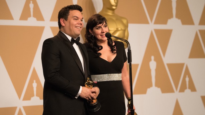 After winning the Oscar for original song for “Remember Me” from “Coco”, Robert Lopez and Kristen Anderson-Lopez pose backstage during the  The 90th Oscars on Sunday, March 4, 2018. Photo by Michael Yada. Courtesy of A.M.P.A.S.