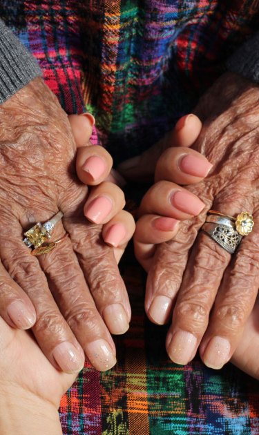 Zully Juarez, age 25, and Maria Gaspar Juan, age 96, holding hands. Maria is Zully’s great-grandmother. Photo by Emaly Escobar, age 17