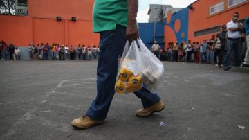 A shopper leaves a supermarket with flour and eggs after waiting for hours for scarce foodstuffs on March 2, 2014 in Caracas, Venezuela. Photo by John Moore/Getty Images