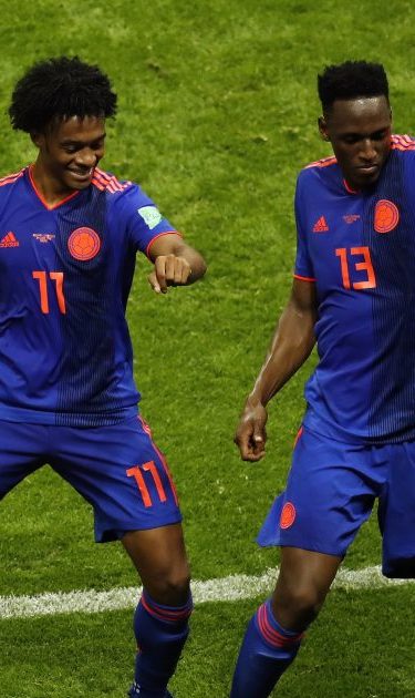 Yerry Mina of Colombia celebrates with teammate Juan Cuadrado after scoring his team's first goal during the 2018 FIFA World Cup. (Photo by Julian Finney/Getty Images)