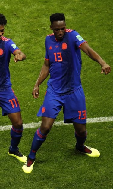Yerry Mina of Colombia celebrates with teammate Juan Cuadrado after scoring his team's first goal during the 2018 FIFA World Cup. (Photo by Julian Finney/Getty Images)
