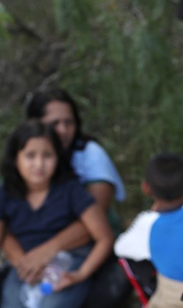 Central American asylum seekers wait as U.S. Border Patrol agents take them into custody on June 12, 2018. Photo by John Moore/Getty Images