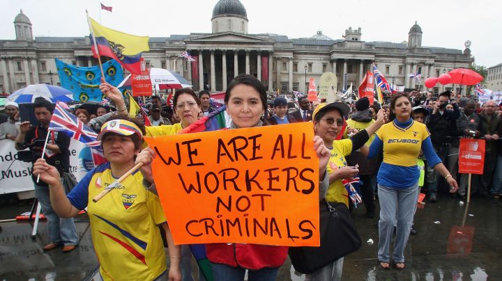 A protester holds a sign during a march hoping to draw attention to claims of exploitation and discrimination of migrant workers. Photo by Matt Cardy/Getty Images