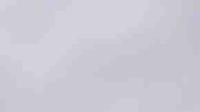 A member of the immigrant caravan climbs atop a gate with a Honduran flag during a clash with Mexican riot police on the border between Mexico and Guatemala on October 19, 2018 in Ciudad Tecun Uman, Guatemala. Photo by John Moore/Getty Images