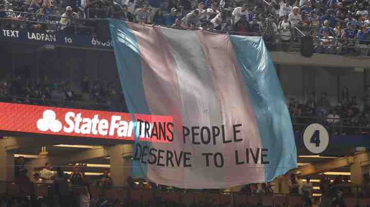 A banner with the words 'Trans People Deserve to Live' is displayed during Game Five of the 2018 World Series. Photo by Sean M. Haffey/Getty Images