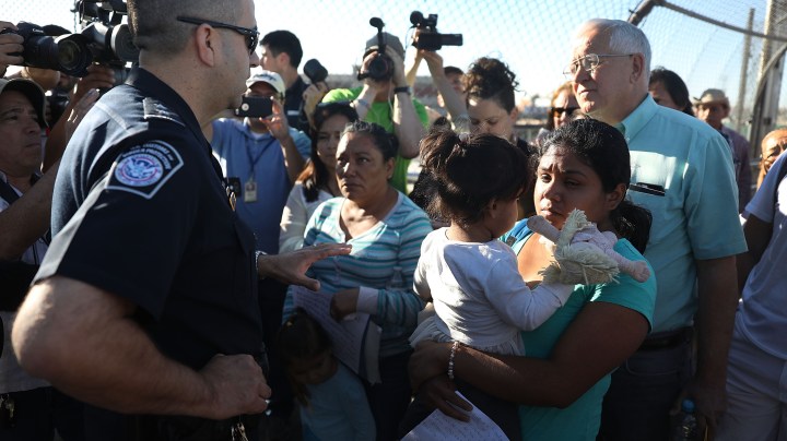 U.S. Border Patrol agent Ray Provencia informs Angelica and Karla (who didn't want their last names used), along with Ruben Garcia, director of the Annunciation House, (R) who was helping them cross, that they will have to wait at the top of the Paso Del Norte Port of Entry, where the U.S. and Mexico border meet, for space to open up at the border processing center so they can ask for asylum on June 20, 2018 in El Paso, Texas. Photo by Joe Raedle/Getty Images