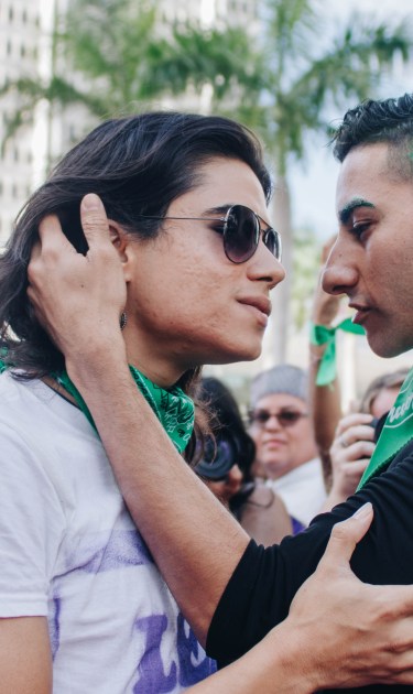 Two Pasarela de Putxs participants embrace (and later kiss) before the crowd. Photo by Mari B. Robles López for Remezcla