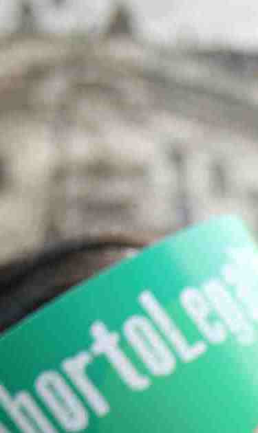 Pro legal abortion activists put on a head band with hashtag 'legal abortion' in front of the National Congress Building. Photo by Mariano Martino/Getty Images