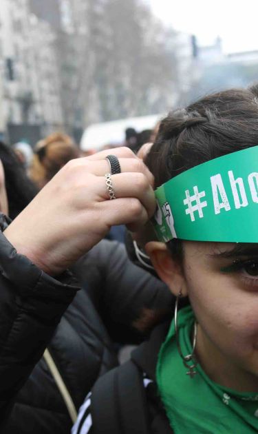 Pro legal abortion activists put on a head band with hashtag 'legal abortion' in front of the National Congress Building. Photo by Mariano Martino/Getty Images