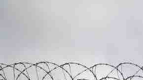 Double strands of concertina wire stretch across the U.S.-Mexico border fence on October 3, 2013 near San Ysidro, California. Photo by John Moore/Getty Images