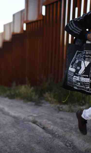 A man walks along the Mexican side of the U.S.-Mexico border barrier on April 2, 2019 in Tijuana, Mexico. Photo by Mario Tama/Getty Images