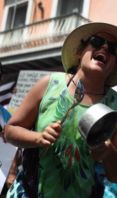 Protesters demonstrate against Ricardo Rossello, the Governor of Puerto Rico, near a police barricade set up along a street leading to the governor's mansion on July 20, 2019 in Old San Juan, Puerto Rico. Photo by Joe Raedle/Getty Images