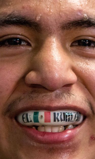Ariel 'Kuman' López shows his mouth guard with his name and the Mexican flag on it after his TKO win against Erick Lainez in Palm Bay, Florida. Photo by Gustavo Martinez Contreras for Remezcla
