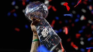A detail of a New England Patriots player raising the Vince Lombardi Trophy at the Super Bowl