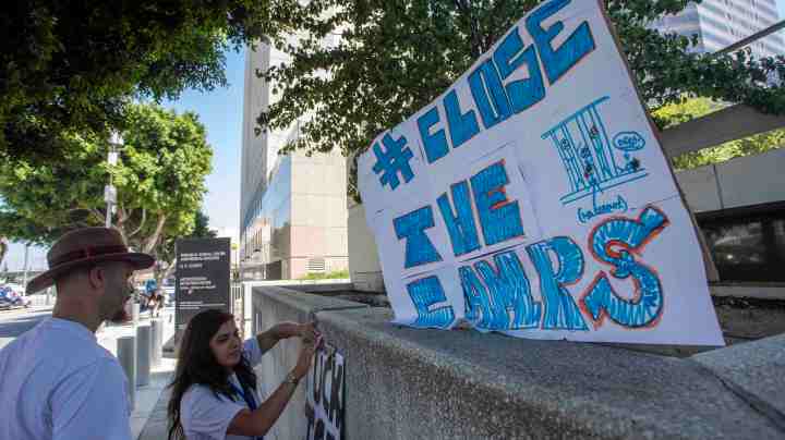 Sage Tello and Lily White (R) put up  protest sign outside the Metropolitan Detention Center prison is seen as mass arrests by federal immigration authorities, as ordered by the Trump administration, were supposed to begin in major cities across the nation on July 14, 2019 in Los Angeles, California. Photo by David McNew/Getty Images