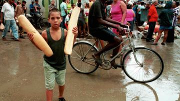 A young Cuban walks home after purchasing bread November 3, 2001 in Havana, Cuba. Photo by Jorge Rey/Getty Images