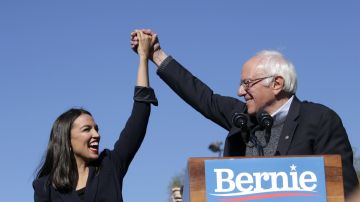 Democratic presidential candidate Sen. Bernie Sanders holds hands with Rep. Alexandria Ocasio-Cortez during his speech at a campaign rally in Queensbridge Park on October 19, 2019 in the Queens borough of New York City.  Photo by Kena Betancur/Getty Images