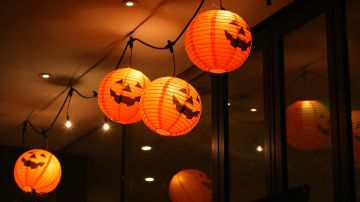 Four Halloween sphere shaped paper lanterns hanging to the ceiling / Getty Images