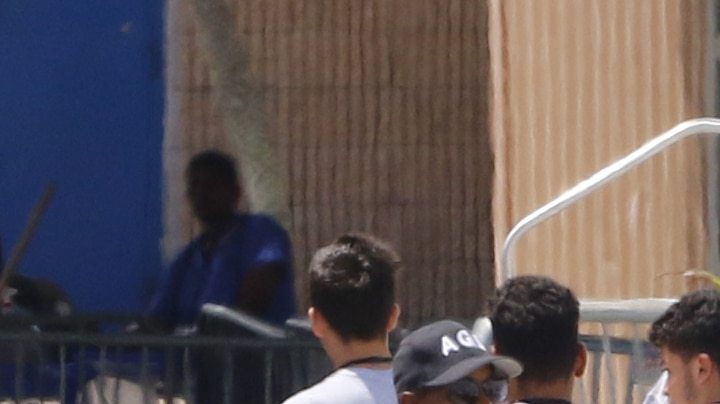 Young men walk in line under the watch of a security officer before U.S. Sen. Bill Nelson (D-FL) and U.S. Rep. Debbie Wasserman Schultz (D-FL) were denied access to the Homestead Temporary Shelter For Unaccompanied Children on June 19, 2018 in Homestead, Florida. Photo by Joe Skipper/Getty Images