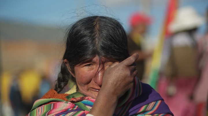 An Indigenous woman prays and cries during a blockade to a Yacimientos Petroliferos Fiscales Bolivianos (YPFB) oil refinery as part of a protest against the new Interim President of Bolivia, Jeanine Añez, on November 17, 2019 in El Alto, La Paz, Bolivia. Photo by Gaston Brito Miserocchi/Getty Images