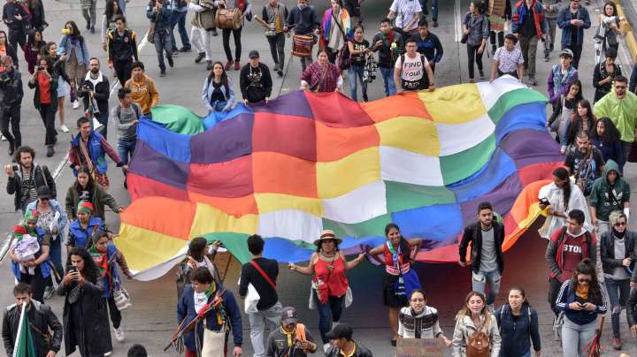 Members of the Indigenous Guard and students march while holding a Wiphala flag during anti-government protests against the politics of President Ivan Duque on the eighth consecutive day, on November 29, 2019 in Bogotá, Colombia. Photo by Guillermo Legaria/Getty Images
