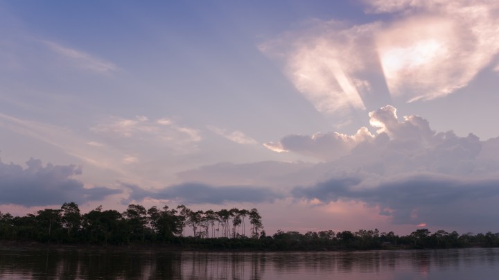 The Putumayo forest in Colombia at sunset with sunbeams over the river. Photo by Ernesto Tereñes / iStock / Getty Images Plus