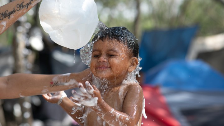 A Honduran mother bathes her son Michael, 2, at a camp for asylum seekers on December 09, 2019 in the border town of Matamoros, Mexico. Photo by John Moore/Getty Images