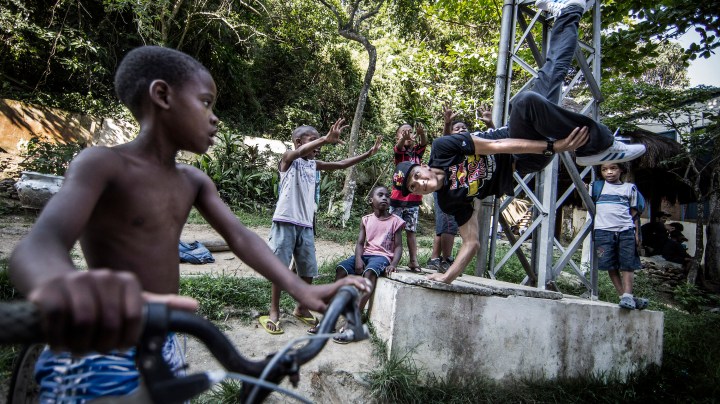 Luis "Arex" Montano of Colombia performs at Favela Cantagalo as local chidren look on prior to the Red Bull BC One breakdancing world final on December 6, 2012 in Rio de Janeiro, Brazil. Photo by Dean Treml/Red Bull via Getty Images