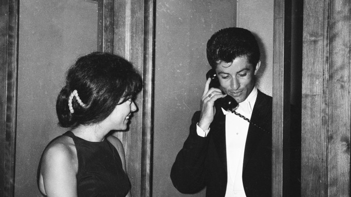 Puerto Rican actor Rita Moreno waits for George Chakiris outside a phone booth at the Academy Awards, Santa Monica, California, April 9, 1962. Photo by Jack Albin/Getty Images
