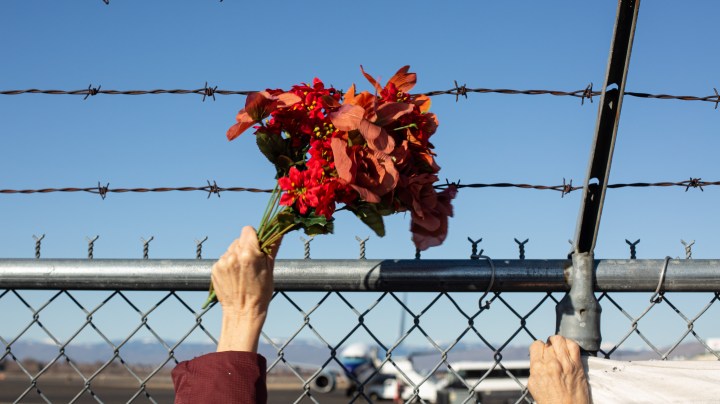 Activists from Yakima Immigrant Response Network wave flowers, hold a banner, and chant as U.S. Immigration and Customs Enforcement (ICE) detainees are loaded onto a Swift Air charter flight at McCormick Air Center on February 18, 2020 in Yakima, Washington. Photo by David Ryder/Getty Images