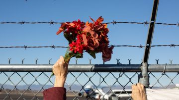Activists from Yakima Immigrant Response Network wave flowers, hold a banner, and chant as U.S. Immigration and Customs Enforcement (ICE) detainees are loaded onto a Swift Air charter flight at McCormick Air Center on February 18, 2020 in Yakima, Washington. Photo by David Ryder/Getty Images