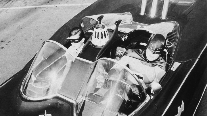 American actors Burt Ward (left), as Robin, and Adam West, as Batman, ride in the Batmobile in a still from the television series, 'Batman,' c. 1967. Photo by 20th Century Fox/Courtesy of Getty Images