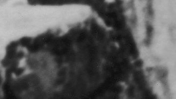 Three Peruvian Indians stand in traditional dress on a masonry ledge of the ancient Incan city of Machu Picchu and look out over a deep valley at one of the Amazon's source streams, early 20th Century. Photo by Henry Clay Gipson/Frederic Lewis/Getty Images