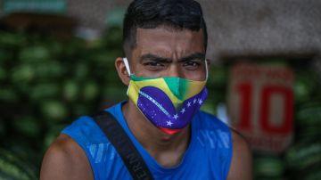 Portrait of a man wearing a protective mask with both Brazilian and Venezuelan flags at Manaus Moderna market, on May 20 2020 in Manaus, Brazil. Photo by Andre Coelho/Getty Images