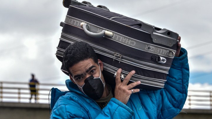 A Venezuelan migrant carrying a bag on his shoulders walks along the side of the highway out of the city on April 06, 2020 in Bogota, Colombia. Photo by Guillermo Legaria/Getty Images