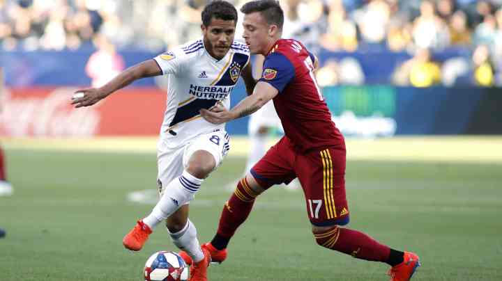 Jonathan dos Santos #8 of Los Angeles Galaxy and Corey Baird #17 of Real Salt Lake fight for control of the ball during a game at Dignity Health Sports Park on April 28, 2019 in Carson, California. Photo by Katharine Lotze/Getty Images