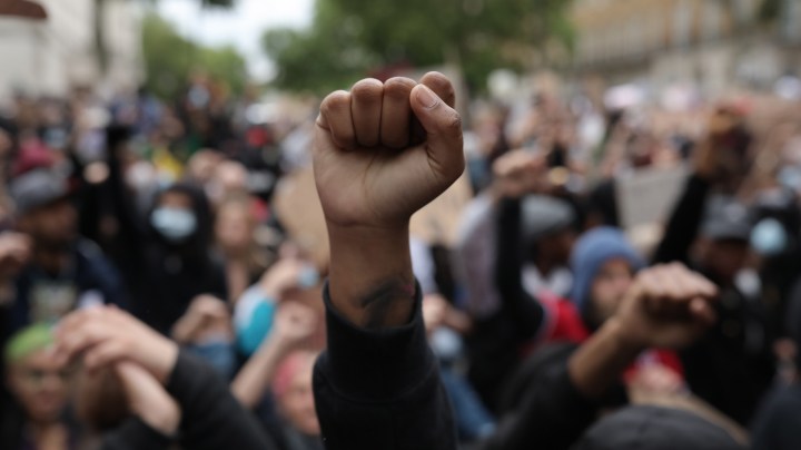 Protesters raise clenched fists during a Black Lives Matter protest outside the Houses of Parliament on June 3, 2020 in London, United Kingdom. Photo by Dan Kitwood/Getty Images