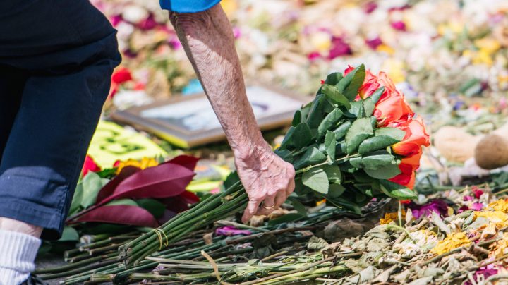 A woman places flowers down at a memorial site for George Floyd on June 10, 2020 in Minneapolis, Minnesota. Photo by Brandon Bell/Getty Images