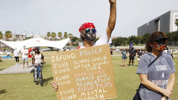Dave Gonzalez stands in protest at the "Love Walk" holding a Defund Police sign before the start of the "Love Walk" at Curtis Hixon Park on June 27, 2020 in Tampa, Florida. Photo by Octavio Jones/Getty Images