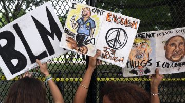 Demonstrators hold up signs against a tall fence at Lafayette Park near the White House while protesting against police brutality and the death of George Floyd, on June 2, 2020 in Washington, DC. Photo by Alex Wong/Getty Images