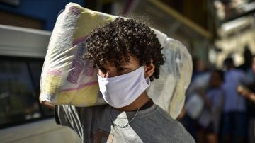 Volunteers carry supplies to poor residents of the Aglomerado da Serra Favela on June 4, 2020 in Belo Horizonte. Photo by Pedro Vilela/Getty Images