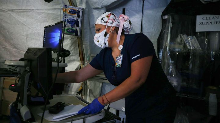 A nurse works in a makeshift tent triage center for patients suspected of being COVID-19 positive outside El Centro Regional Medical Center in hard-hit Imperial County on July 21, 2020 in El Centro, California. Photo by Mario Tama/Getty Images