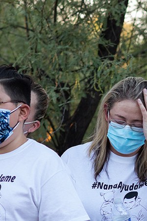 Community members and family wear shirts that read "Nana Ayudame or Nana, help me" in Spanish at a vigil for Carlos Adrián Ingram Lopez on June 25, 2020 in Tucson, Arizona. Photo by Caitlin O'Hara/Getty Images