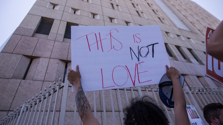 People demonstrate and call out words of encouragement to detainees held inside the Metropolitan Detention Center after marching to decry Trump administration immigration and refugee policies on June 30, 2018 in Los Angeles, California. Photo by David McNew/Getty Images.