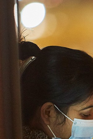 A woman wearing a mask eyes her smartphone as she waits for a tram on October 14, 2020 in Amsterdam, Netherlands. Photo by Pierre Crom/Getty Images