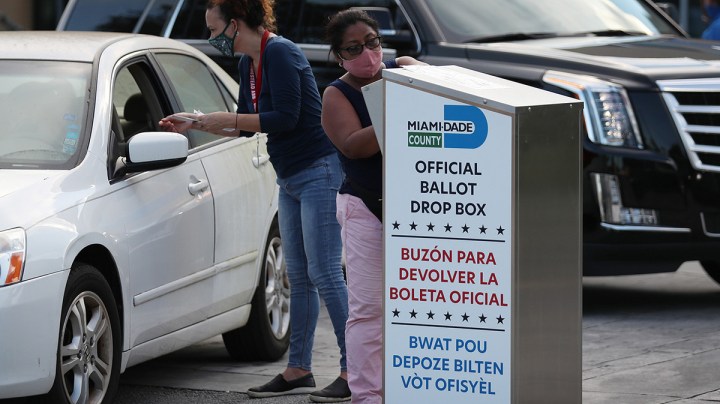 Poll workers at the Miami-Dade County Elections Department deposit peoples' mail in ballots into an official ballot drop box on primary election day on August 18, 2020 in Doral, Florida. Photo by Joe Raedle/Getty Images