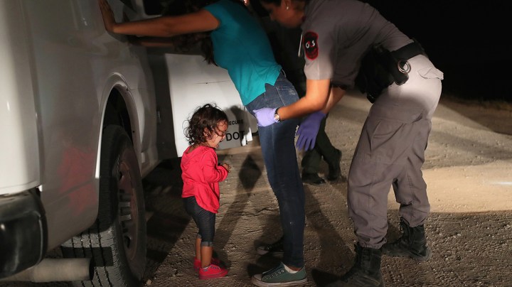 A two-year-old Honduran asylum seeker cries as her mother is searched and detained near the U.S.-Mexico border on June 12, 2018 in McAllen, Texas. Photo by John Moore/Getty Images