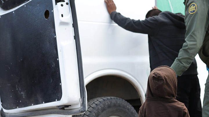 A child watches as a U.S. Border Patrol agent searches a fellow Central American immigrant after they crossed the border from Mexico on February 01, 2019 in El Paso, Texas. Photo by John Moore/Getty Images