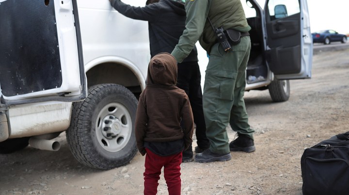 A child watches as a U.S. Border Patrol agent searches a fellow Central American immigrant after they crossed the border from Mexico on February 01, 2019 in El Paso, Texas. Photo by John Moore/Getty Images