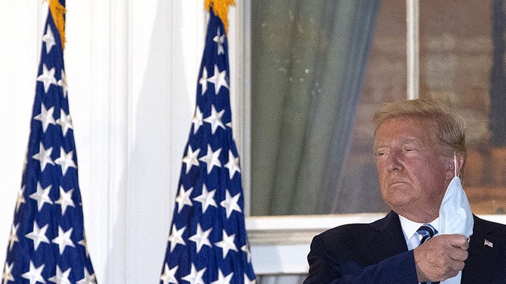President Donald Trump removes his mask upon return to the White House from Walter Reed National Military Medical Center on October 05, 2020 in Washington, DC. Photo by Win McNamee/Getty Images.
